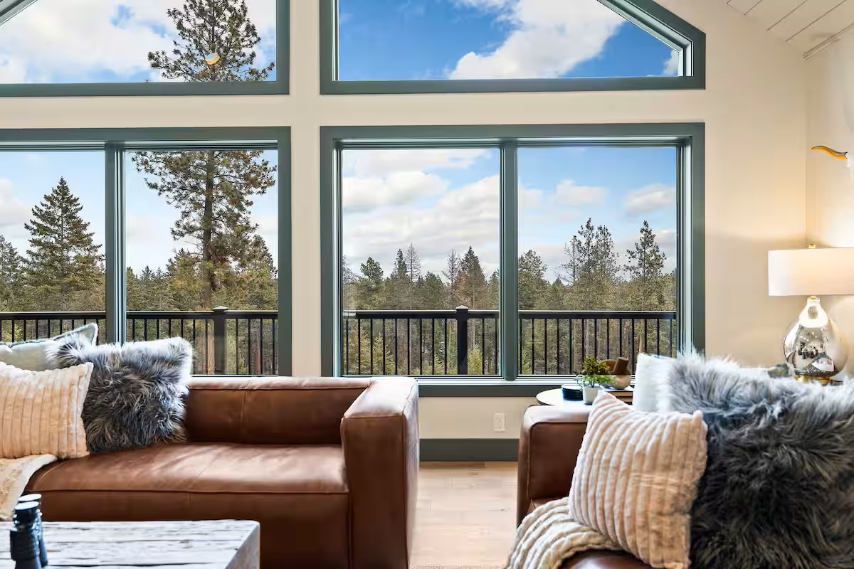Great room with vaulted ceiling, fireplace and forest views